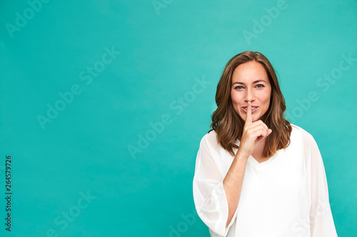 Quadro em tela Gorgeous woman with a secret against blue background