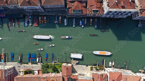 Aerial drone top view photo of iconic and unique colourful Gondolas in small Canal near Rialto bridge, Venice, Italy