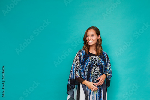 Blue kaftan girl smiling in studio, looking away photo