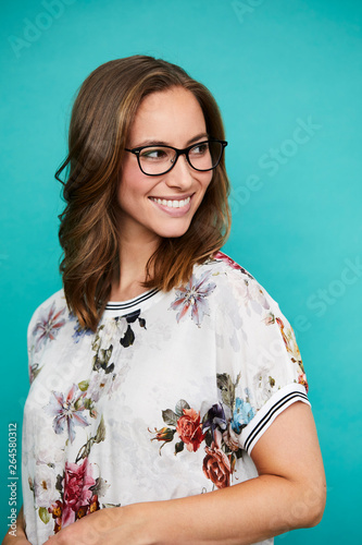 Smiling woman in glasses, looking over shoulder