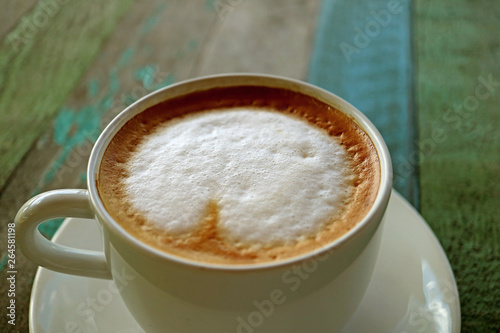 Closeup Fluffy Milk Foam of Cappuccino Coffee Served on Rustic Wooden Table
