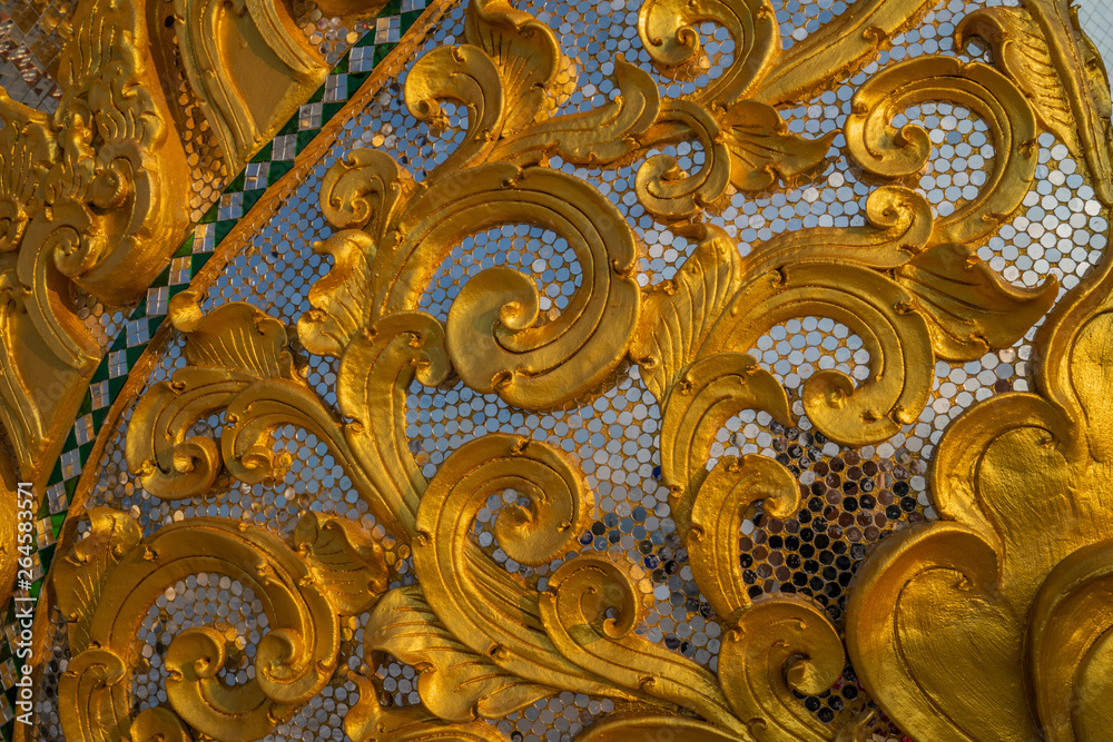 Golden swirl ornaments with glass mosaic fragment of Thai temple decoration 