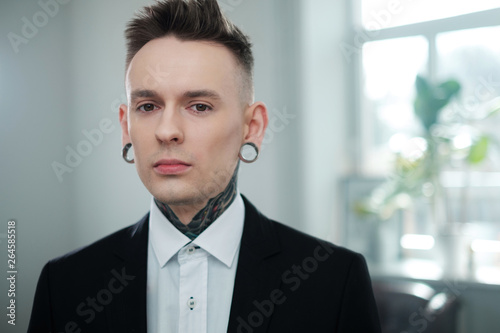 Portrait of alternative model with earplugs and tattoo photo