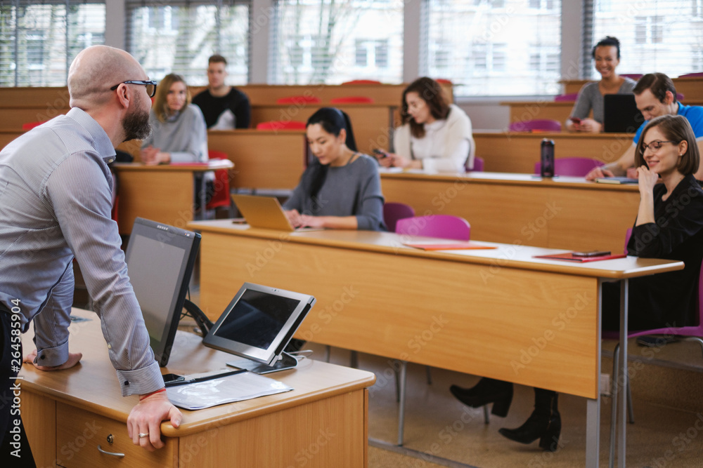 Lecturer and multinational group of students in an auditorium Lecturer and multinational group of students in an auditorium