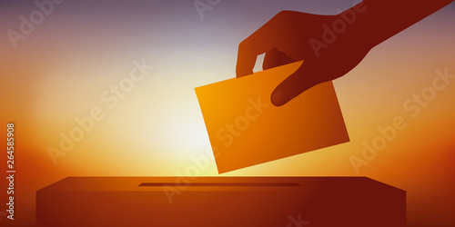 Concept du leadership et de l’élection démocratique d’un candidat avec la main d’un électeur tenant son bulletin de vote avant de le glisser dans l’urne.