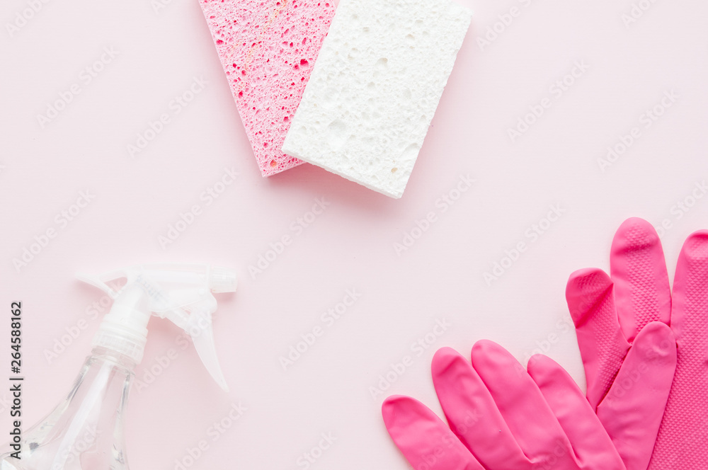 spring cleaning supplies on a pink background with copy space