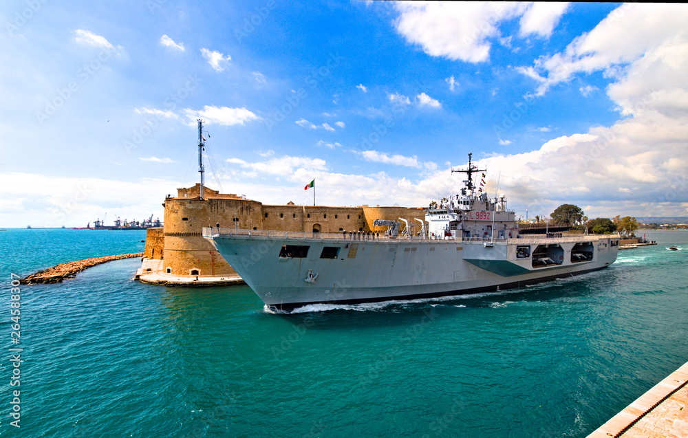 Naklejka premium Taranto, Italy - April 06, 2019: the navigable canal, opening of the bridge and the passage of the Italian navy ship San Giorgio in the navigable channel