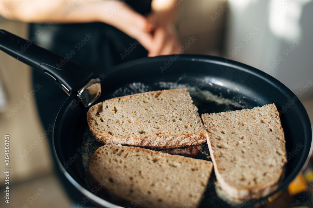 Chef toasting whole wheat bread in a pan with butter