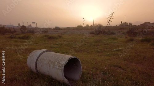 Tubo in amianto cancerogeno e velenoso abbandonato su un terreno con cielo avvolto dalla tempesta di sabbia. Concetto di inquinamento industriale. photo