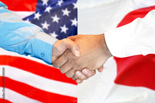 Business handshake on the background of two flags. Men handshake on the background of the American and Japanese flag. Support concept