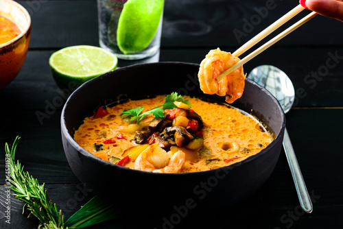 Spicy seafood noodles on black wood background.