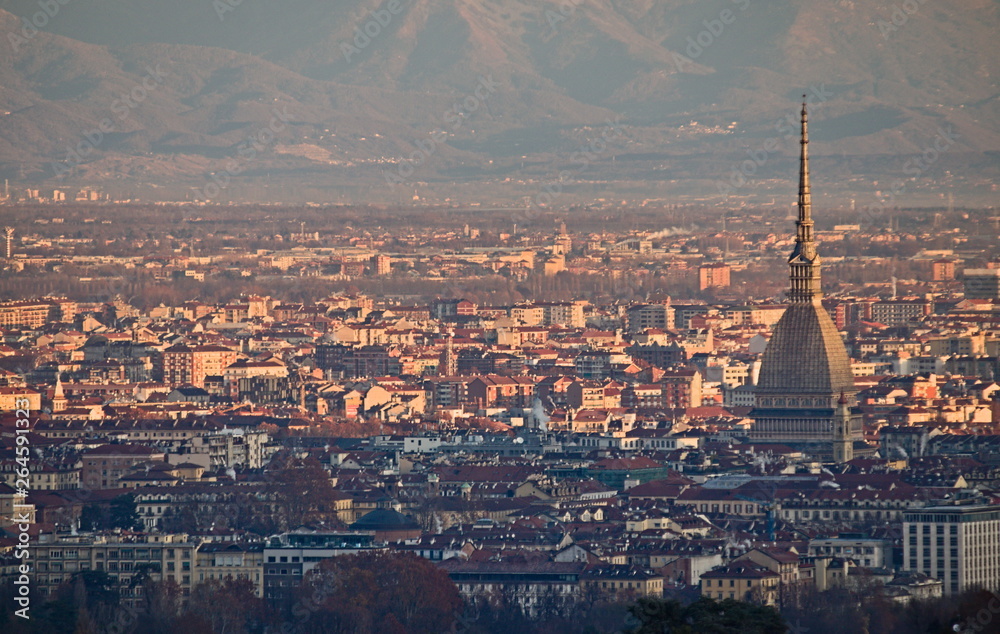 Panorama of Turin at sunrise, overlooking the city center and the Mole Antonelliana, a backdrop of snow-capped mountains illuminated by pink light of the rising sun