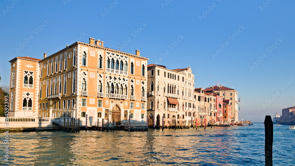 Fototapeta premium Typical view of the old city of Venice, Italy, with canals, bridges, ancient buildings immersed in water, boats and gondolas