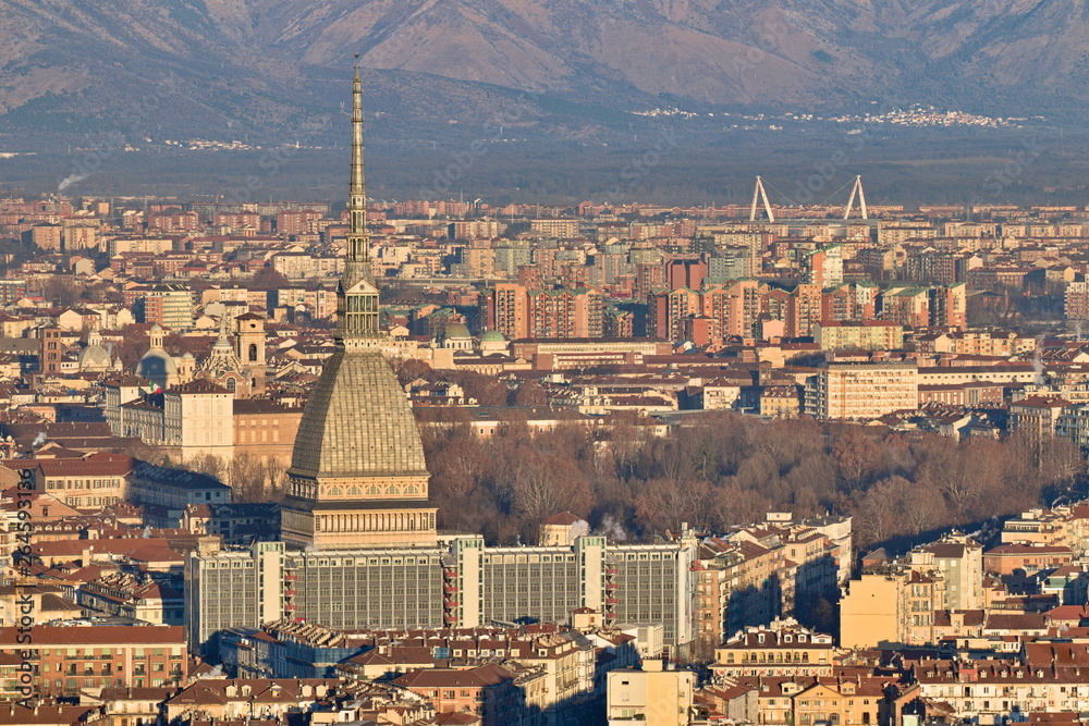 Aerial view of Turin, Italy, at sunset, with the city center and the Mole Antonelliana, sun is giving its first light on the city