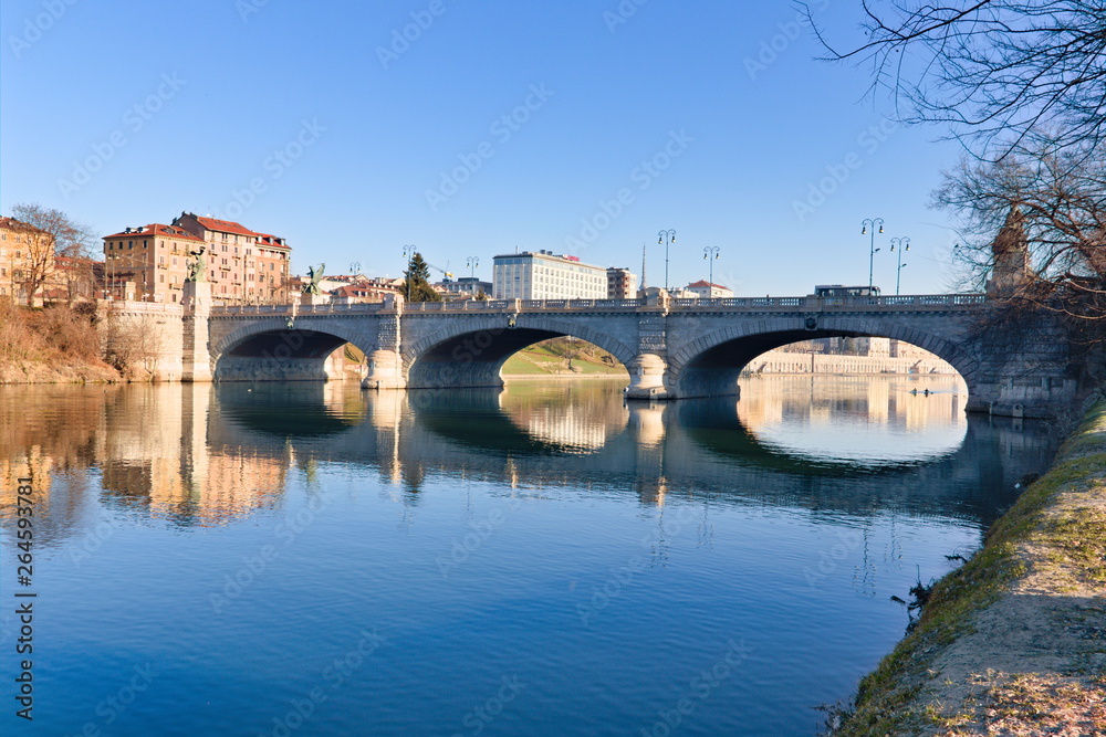 Po riverside in a bright spring morning with a blue sky, bridges and reflections on the water surface, Turin, Piedmont, Italy