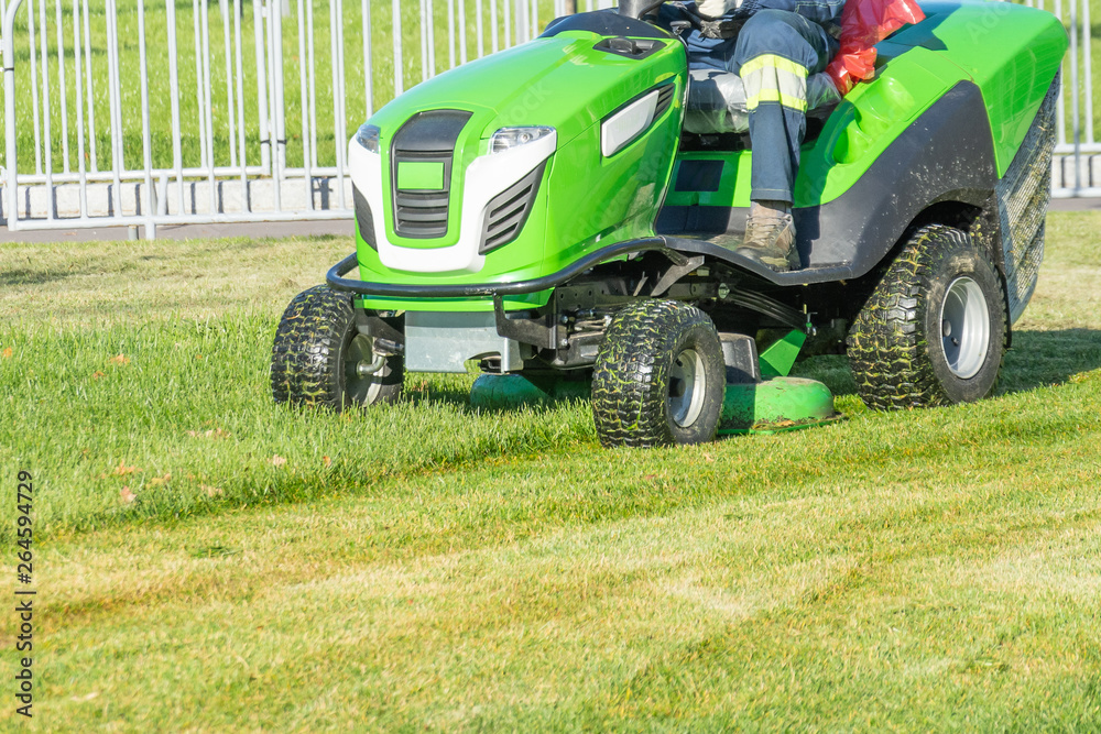 Ride lawn mower mows a green fresh grass. Ride lawn mower mows a green fresh grass.