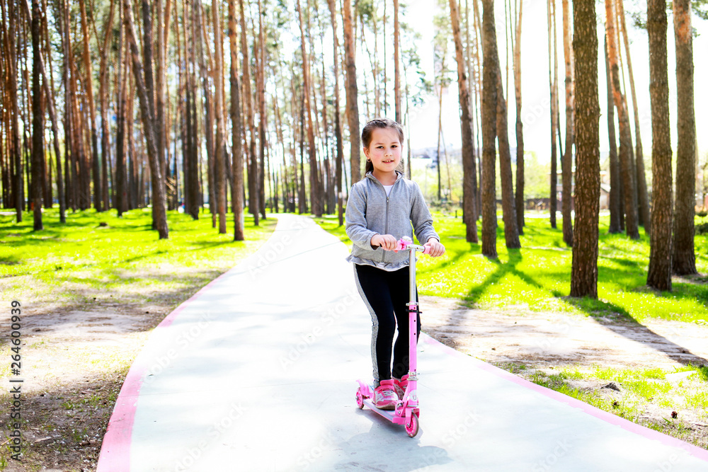 little girl riding a scooter in the park