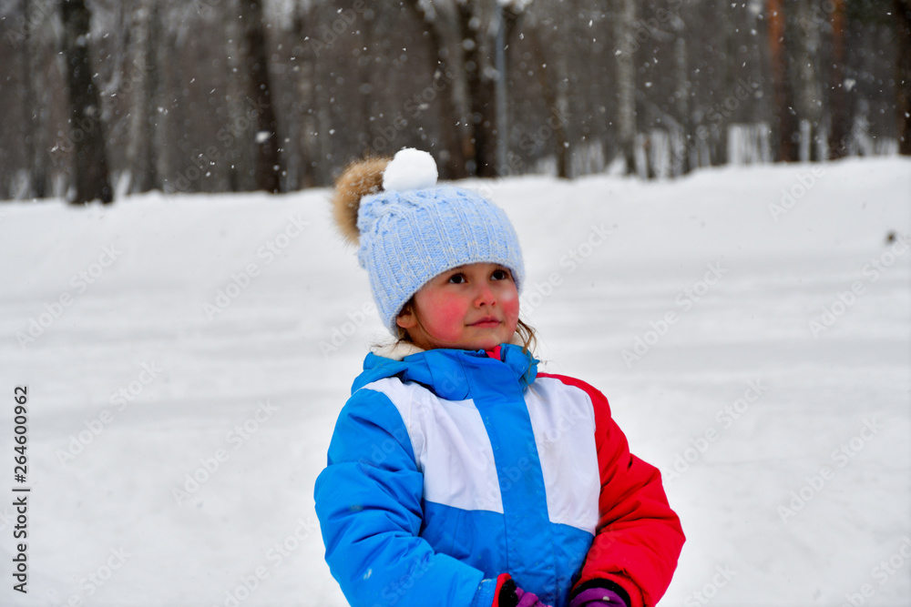 funny little girl playing with snow. child with snowball on a walk in the winter. Kids play outside. Winter fun concept. funny little girl playing with snow. child with snowball on a walk in the winter. Kids play outside. Winter fun concept.
