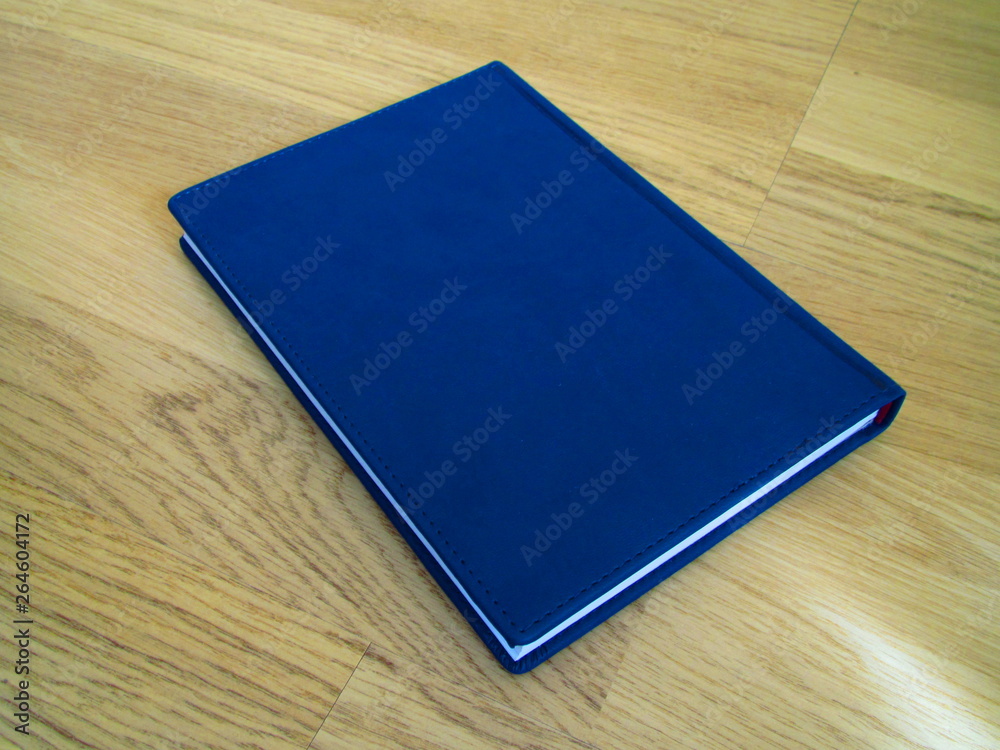 Blue leather notebook on a wooden floor Blue leather notebook on a wooden floor