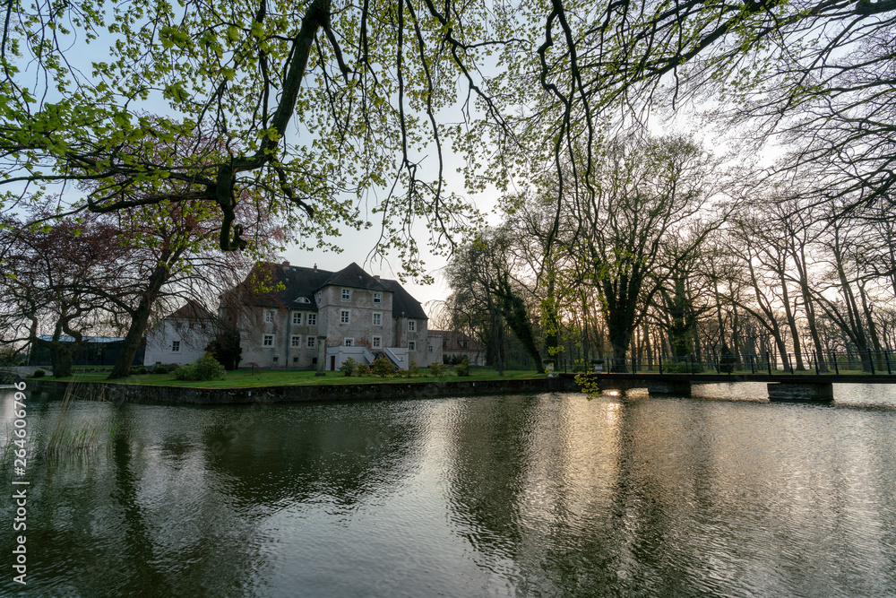 Historisches Wasserschloss Mellenthin auf Usedom mit Burggraben bei Sonnenuntergang 
