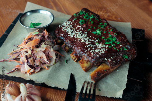 grilled ribs with spices sesame and greens decorated with garlic sauce and salad