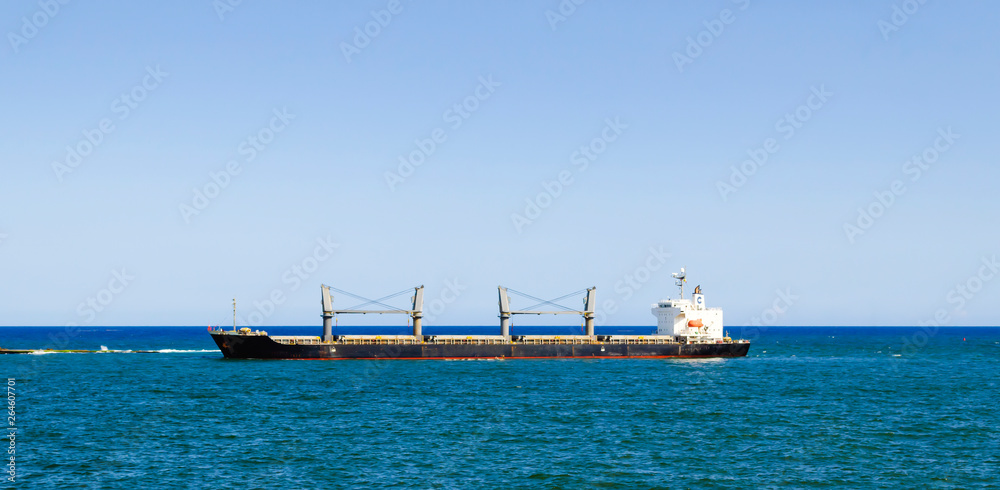 cargo boat arriving at the entrance of the port of Santo Domingo, Dominican Republic with a tropical blue sea