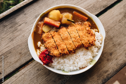 Rice with deep fried pork and curry in Japanese style or katsu kare in white plate ready to eat.