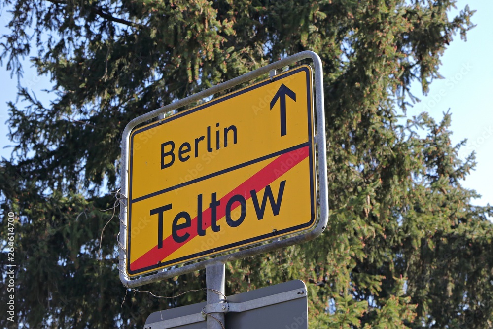 City of Berlin information road sign Teltow exit with a sunny blue sky background and trees