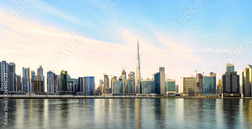 Stunning panoramic view of the Dubai skyline during sunset with the magnificent Burj Khalifa and many other buildings and skyscrapers reflected on a silky smooth water. Dubai  United Arab Emirates.