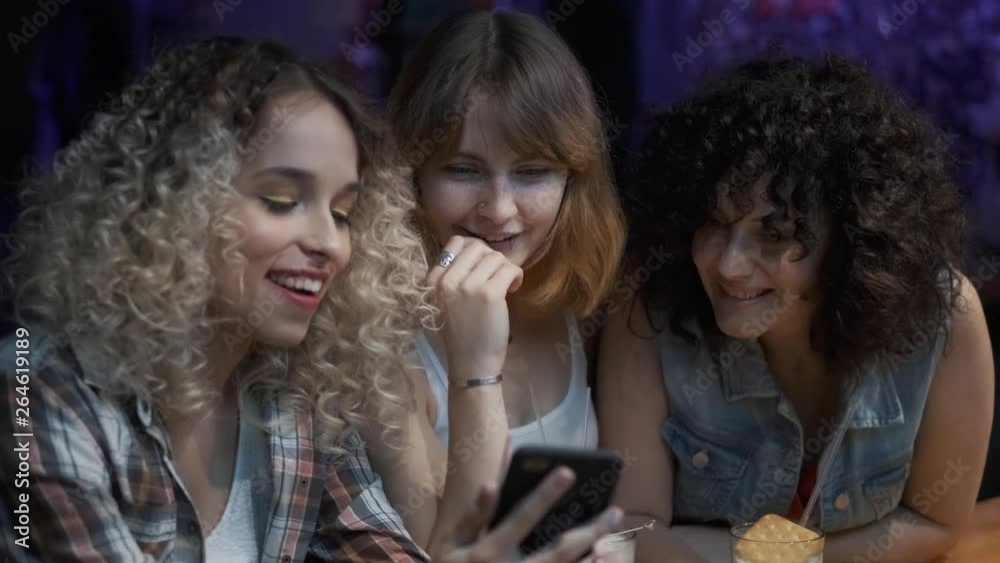 friends chat sitting at the bar. girls have fun together at a party.
