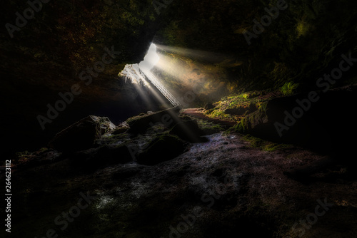 Underground cave  the stairs  in Bulgaria with sun rays from hole in cave entrance