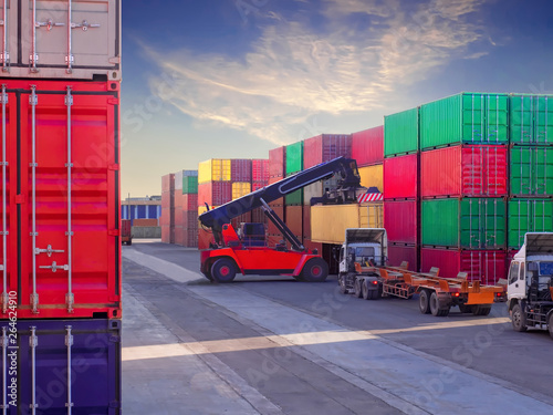 Fotografie Reach stacker is working at container depot service, Reach stacker lift on container to truck