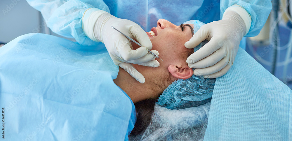 Several doctors surrounding patient on operation table during their work. Team surgeons at work in operating room Several doctors surrounding patient on operation table during their work. Team surgeons at work in operating room