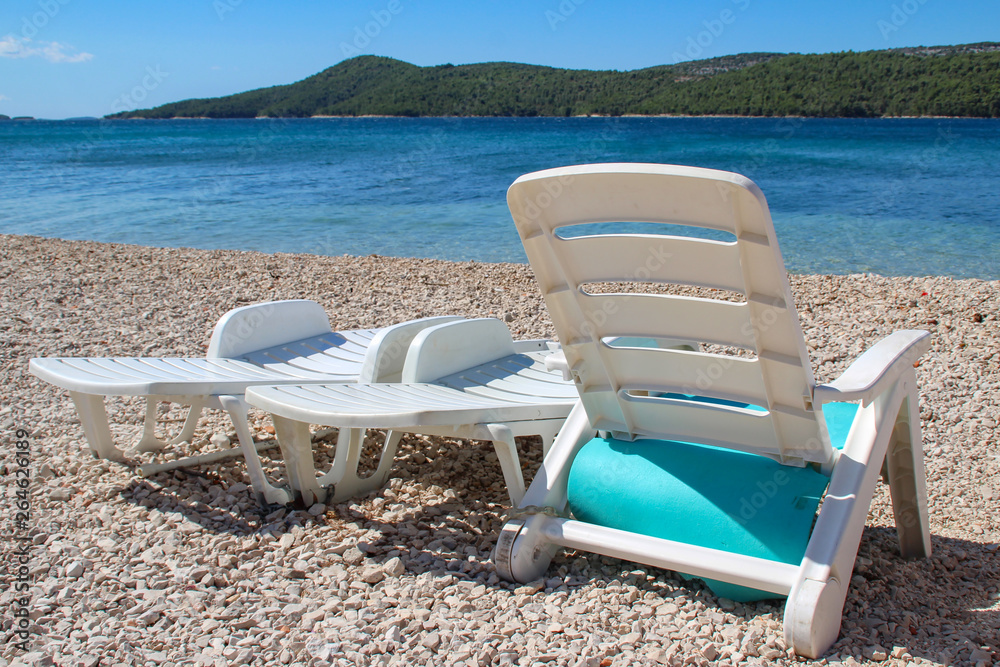 Beach. White beds stand at Pebble Beach. Beach. White beds stand at Pebble Beach.