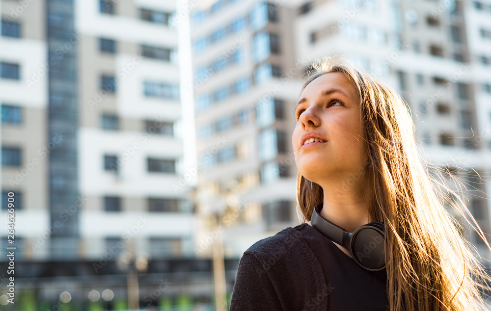 Outdoor portrait of young teenager brunette girl with long hair. girl on city in black dress Outdoor portrait of young teenager brunette girl with long hair. girl on city in black dress