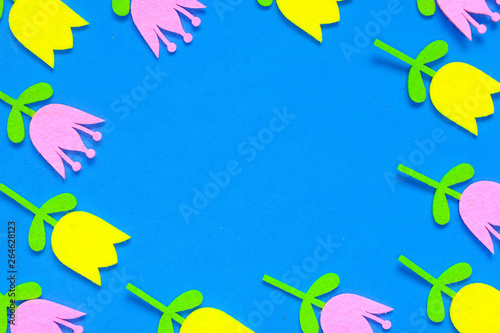 Yellow and pink felt tulip flower cutouts on a blue background