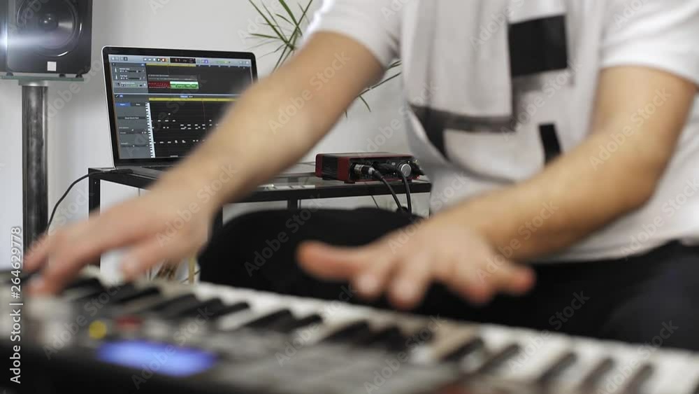 Close up of musician playing midi keyboard in home music studio. Close up of musician playing midi keyboard in home music studio.