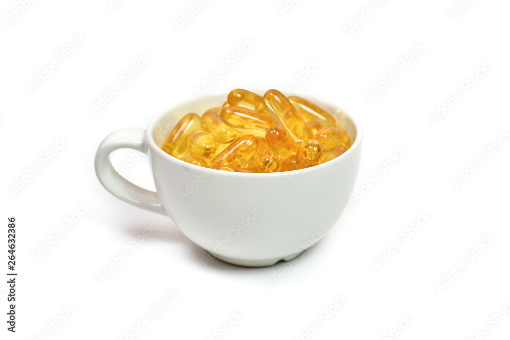 Supplementary food for good health. Gold fish oil in cup isolated on white background. Supplementary food. Omega 3. Vitamin E. Capsules salmon fish oil. Supplementary food for good health. Gold fish oil in cup isolated on white background. Supplementary food. Omega 3. Vitamin E. Capsules salmon fish oil.