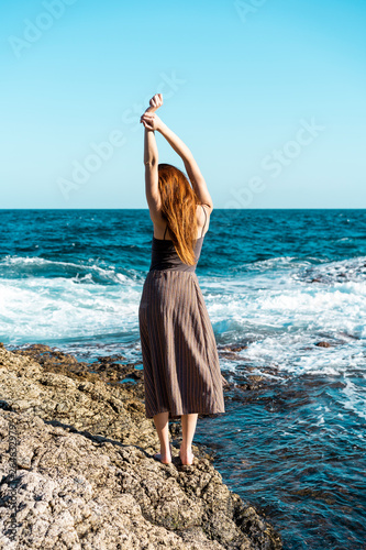 Spain, Canary Islands, Fuerteventura, woman standing at the coast photo