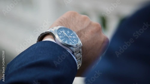 businessman looking at his watch on his hand, watching the time
