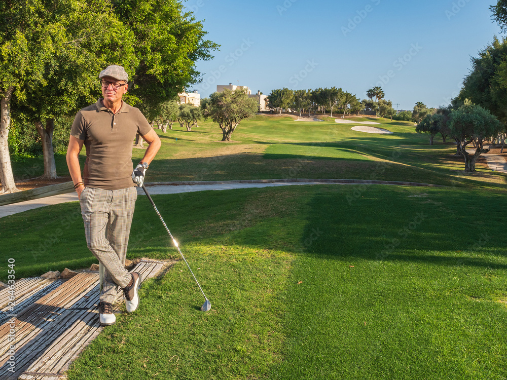 athletic and attractive man playing golf on a sunny day