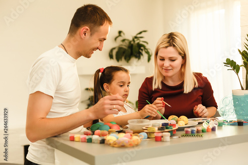 Happy easter! family mother, father and children having fun paint and decorate eggs for holiday