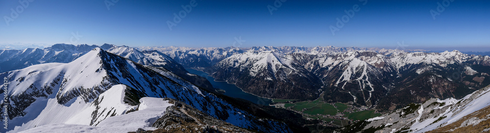 Bergpanorama vom Unnütz über den Aachensee bis in das Karwendel im Frühjahr mit Schnee auf den Bergen und grünem Tal Bergpanorama vom Unnütz über den Aachensee bis in das Karwendel im Frühjahr mit Schnee auf den Bergen und grünem Tal