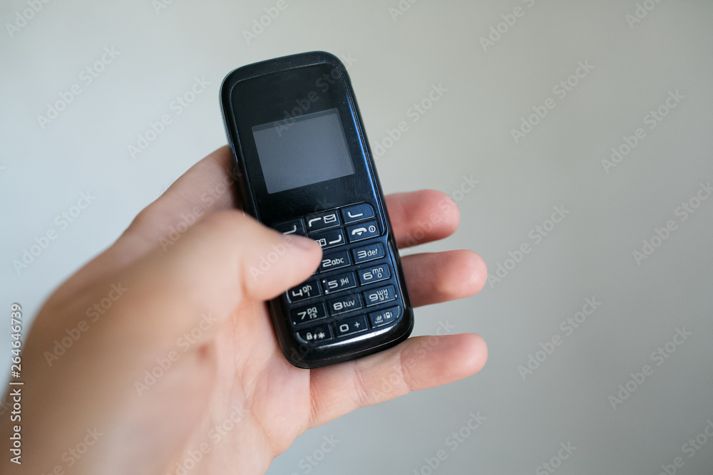 Close-up of man hand holding old black mobile phone Close-up of man hand holding old black mobile phone
