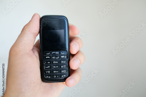 Close-up of man hand holding old black mobile phone
