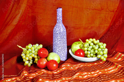 Fototapeta Naklejka Na Ścianę i Meble -  Still life with bottle and fruit: peaches, apples and grapes in Oriental style