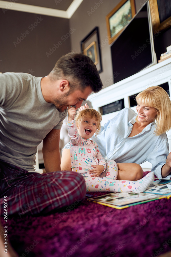 Obraz premium Smiling family having fun with cute child