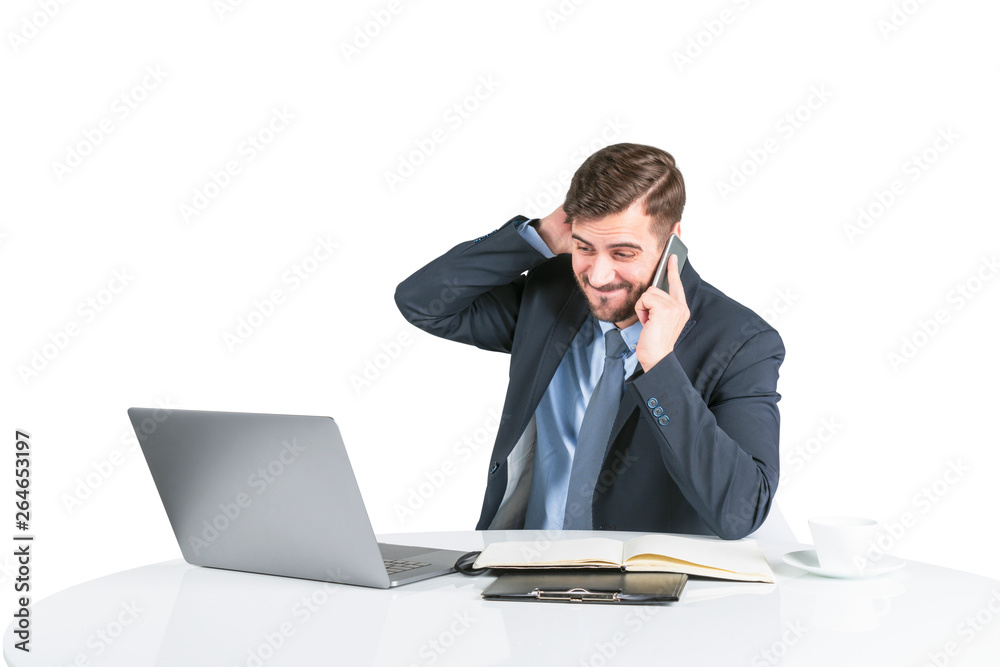 Concerned young man in suit on phone at table Concerned young man in suit on phone at table