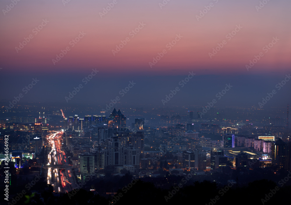 Red glow after sunset over Almaty with highrise towers and Al Farabi Avenue Kazakhstan