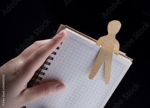 Man shape cut out of paper in notebbok photo